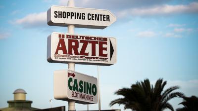 Hinweisschild "Deutsche Ärzte" und "Shopping Center" auf Gran Canaria