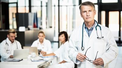 Erfahrener Arzt, Kollegen im Hintergrund