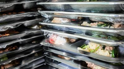 Eingeschweißtes Essen auf gestapelten Metalltabletts