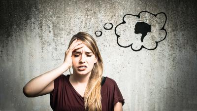 Eine Frau mit verzerrtem Gesichtsausdruck und über ihr eine Sprechblase mit einem Daumen nach unten