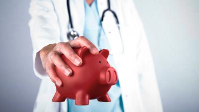 Arzt mit rotem Sparschwein