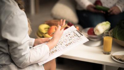 Ernährungsmedizin: Ärztin mit Flipchart und gesunden Lebensmitteln