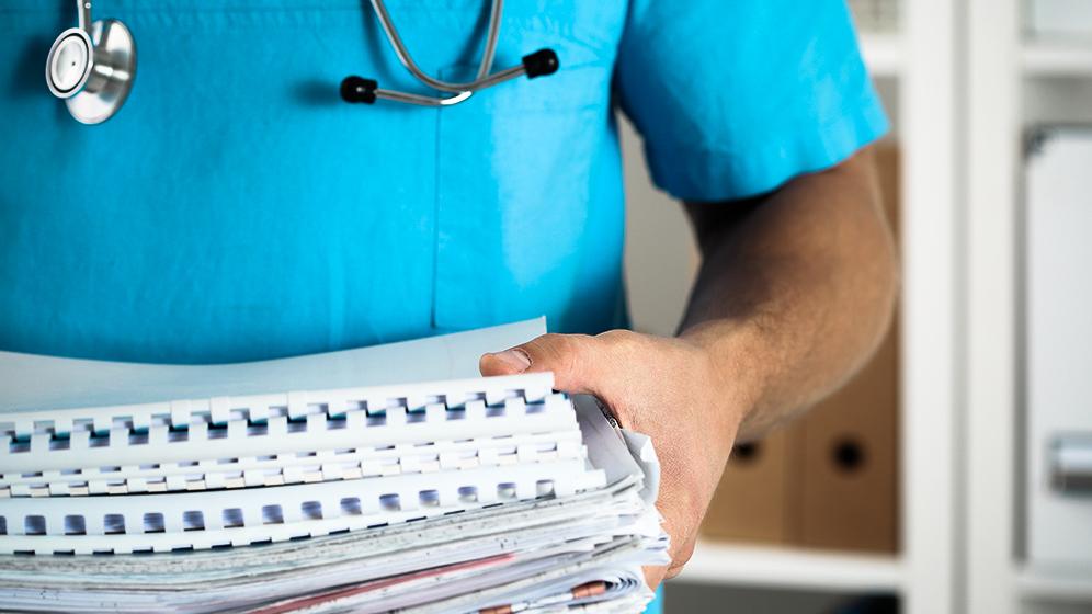 Arzt trägt Akten herum