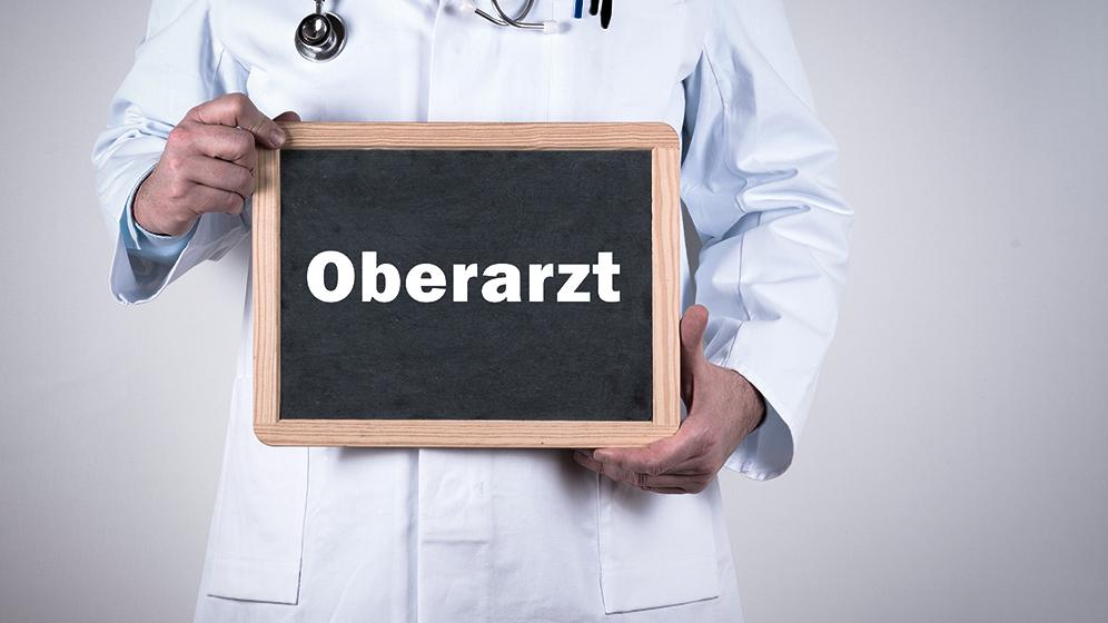 Arzt hält Schild "Oberarzt"